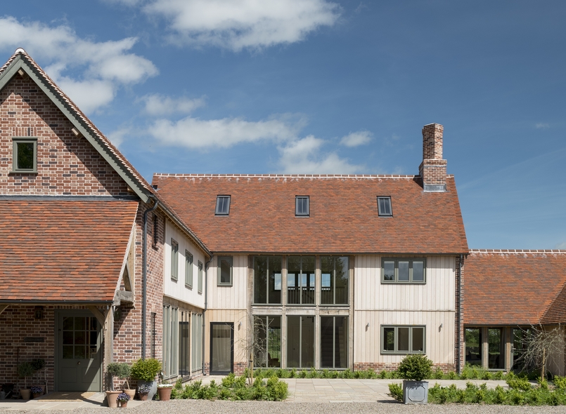 Large oak frame house in the countryside with weatherboarding and large windows 