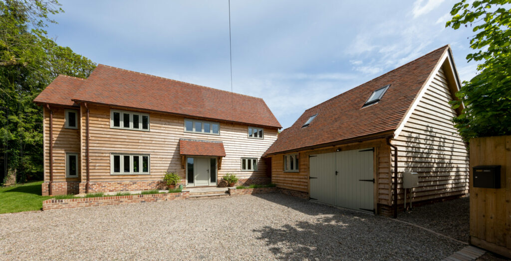 Country home clad in weatherboard with gravel driveway and garage