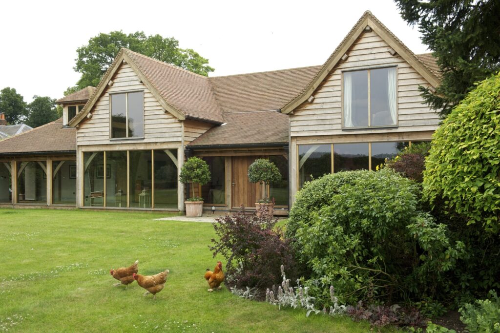rear of oak frame house with garden and hens
