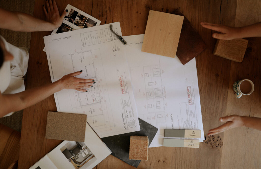 Table with two people discussing house drawings and plans